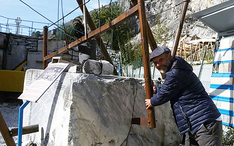 guided visit of the quarry museum, umberto sawing by hands a marble block