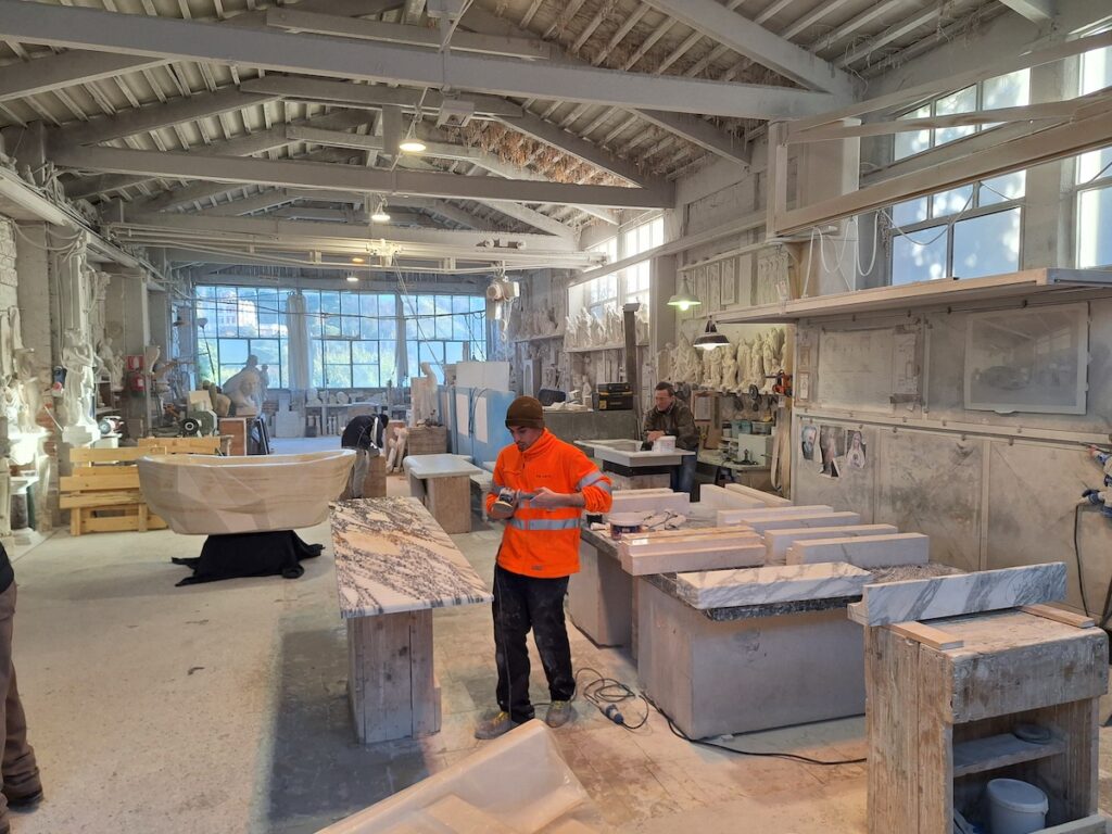 marble artisans at work in a carrara marble workshop of architects and designers
