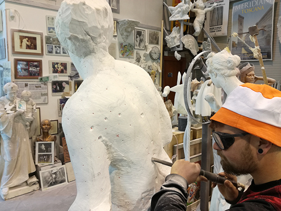 Sculpture workshop in Carrara – artisan carving marble during shore excursion